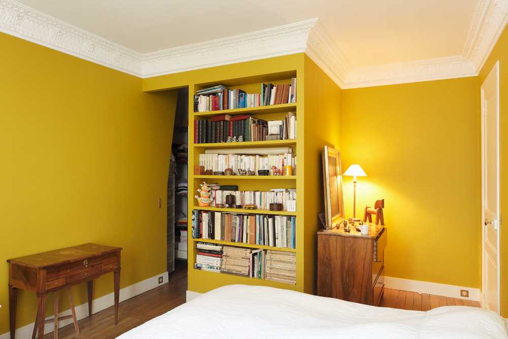 Chambre jaune avec moulures au plafond
