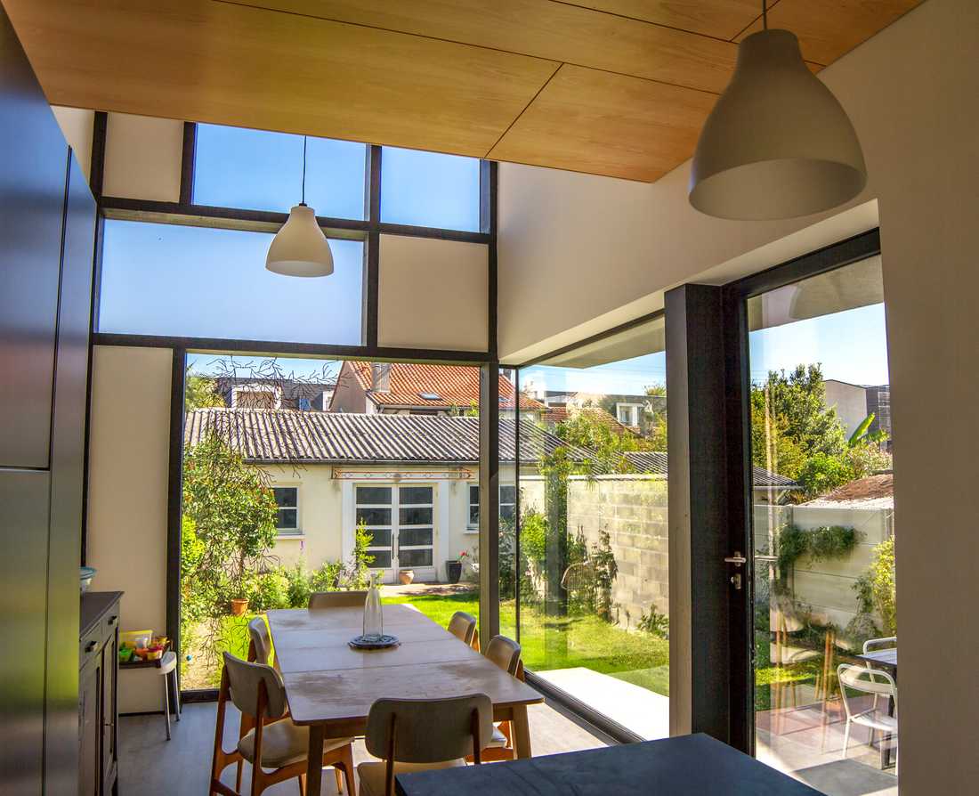 Intérieur de l'extension da la maison avec une verrière vers l'extérieur